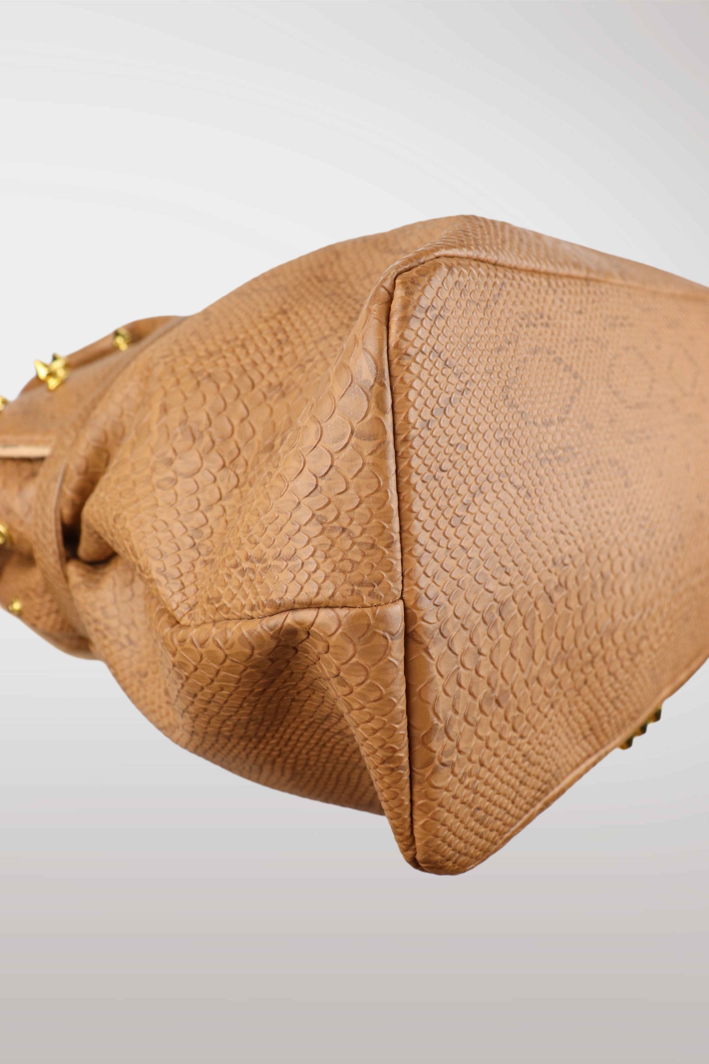 Close-up of a brown textured handbag on a light gray background