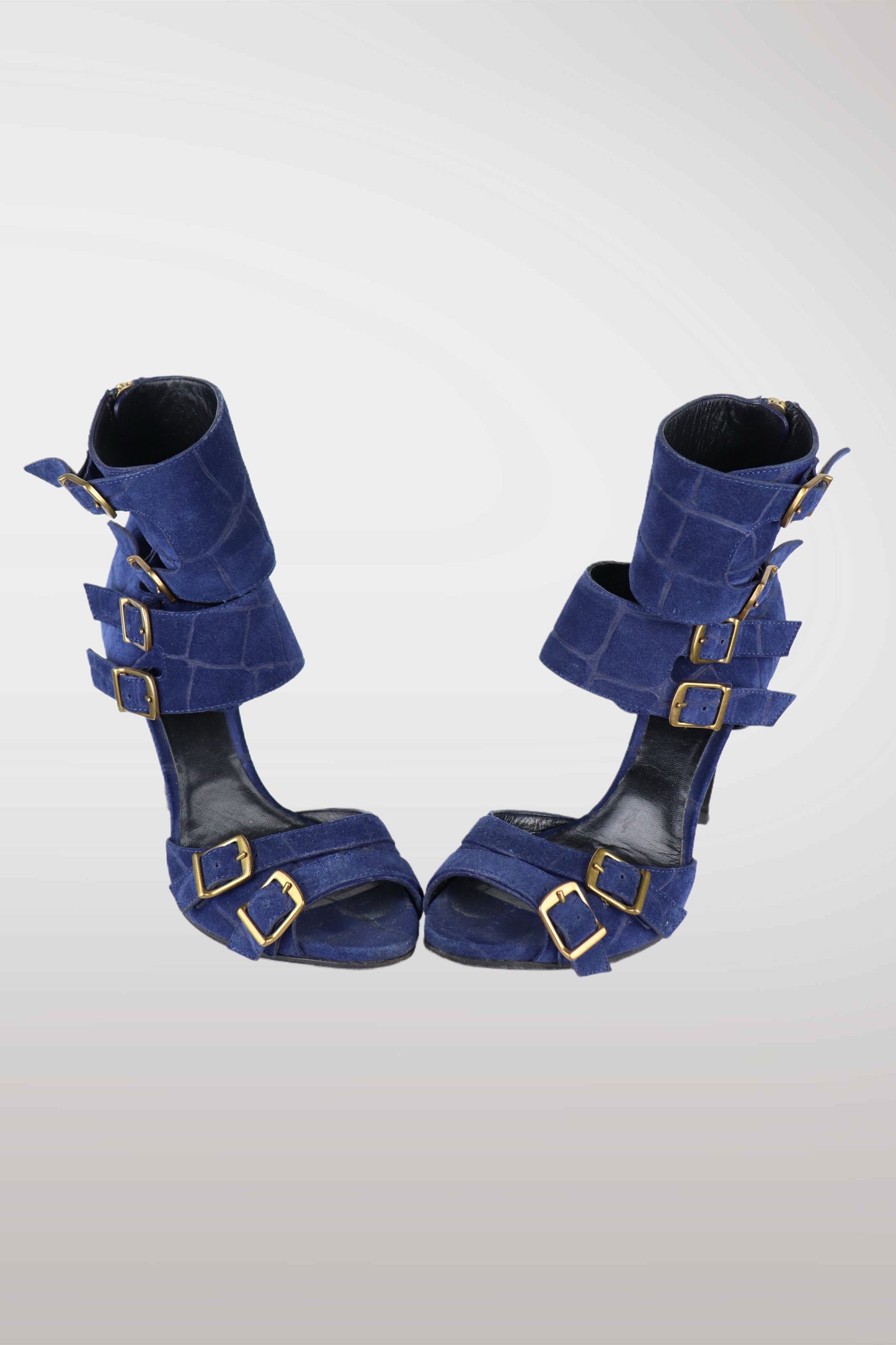 Pair of emilio pucci blue high-heeled shoes with gold buckles on a white background