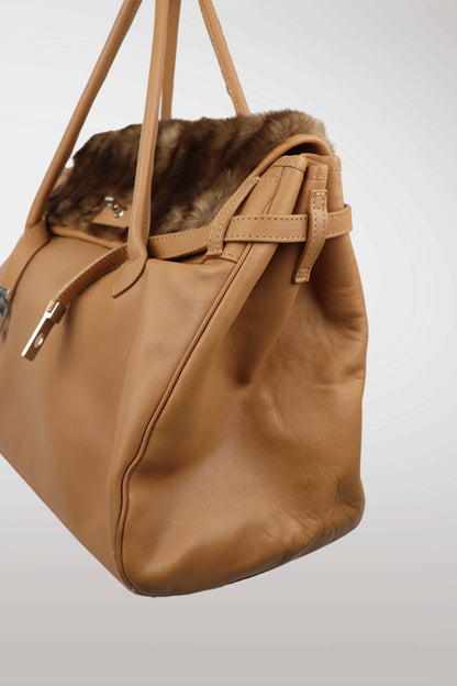 Brown handbag with fur trim on a light gray background