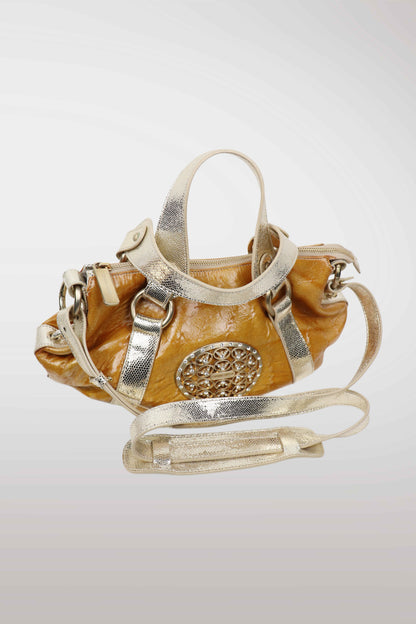 Designer handbag with gold and silver accents on a light gray background