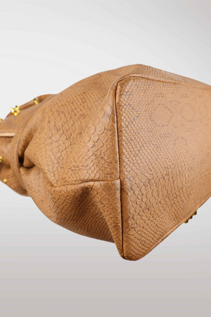 Close-up of a brown textured handbag on a light gray background