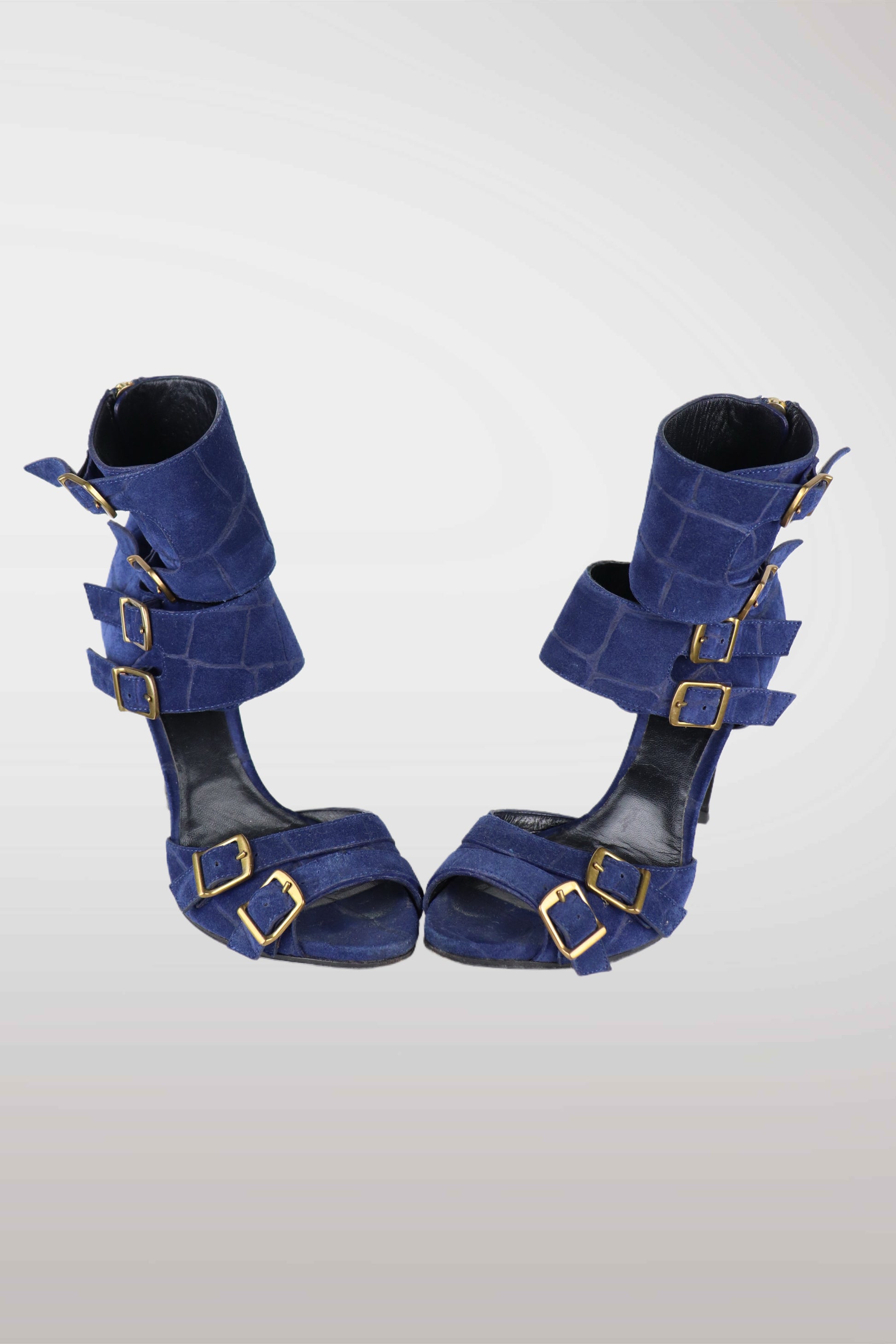 Pair of emilio pucci blue high-heeled shoes with gold buckles on a white background