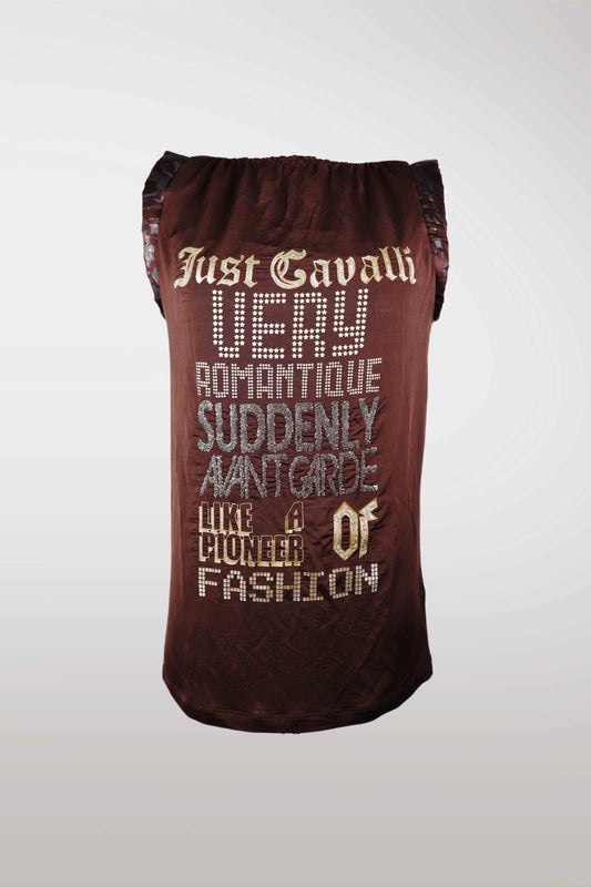 A dark brown velvet-like drawstring bag with decorative text on the front reading 'Just Cavalli VERY ROMANTIQUE SUDDENLY AANTGARDE LIKE A PIONEER OF FASHION' in cream and silver lettering, set against a light gray gradient background.