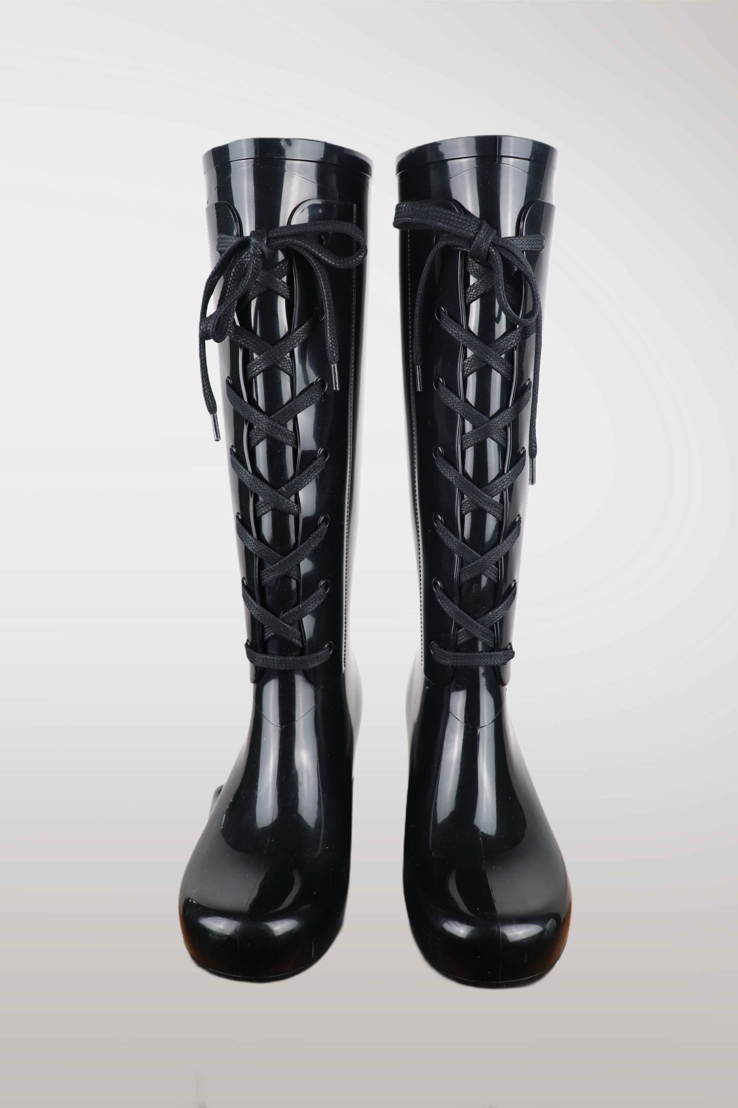 Yves Saint Laurent women’s black wedge rain boots with lace-up front design, glossy waterproof rubber finish, mid-calf height, and hidden platform heel — luxury designer rain footwear combining elegance and practicality, perfect for chic all-weather style