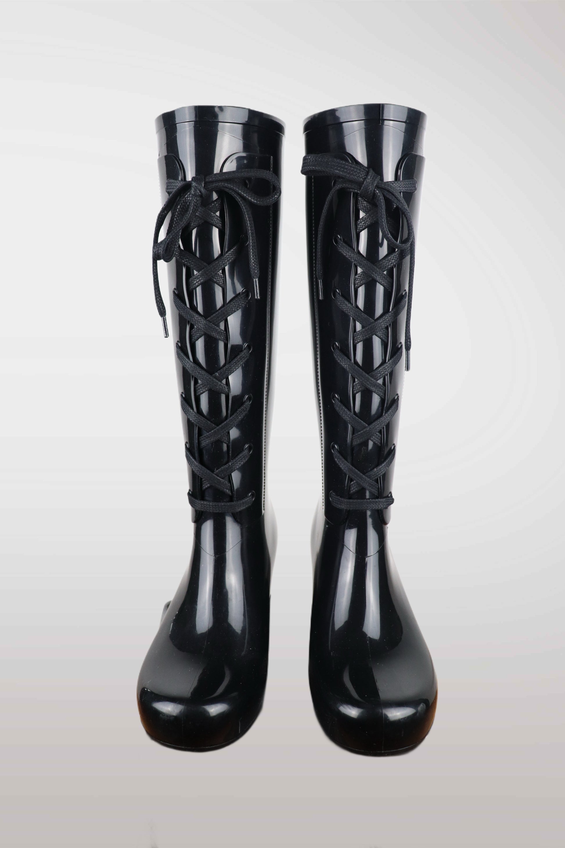 Yves Saint Laurent women’s black wedge rain boots with lace-up front design, glossy waterproof rubber finish, mid-calf height, and hidden platform heel — luxury designer rain footwear combining elegance and practicality, perfect for chic all-weather style